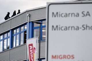 Des militants cagoulés de la cause animale occupent le toit de l'usine Micarna à Courtepin (FR) KEYSTONE/LAURENT GILLIERON