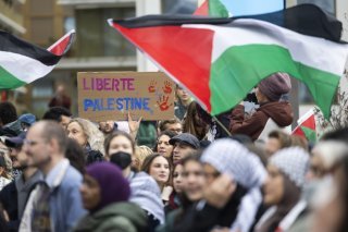 Des manifestants pro-palestiniens brandissent des drapeaux, des banderoles et des pancartes lors d'un rassemblement non autorise en solidarite avec le peuple palestinien ce samedi 1 novembre 2025 a Sion, en Suisse. (KEYSTONE/Cyril Zingaro)