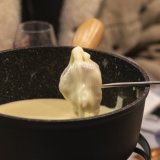 Avant de déguster un bon repas, par exemple une fondue, divers restaurants valaisans offriront à leurs clients un peu de littérature (photo d'illustration). KEYSTONE/LAURENT MERLET