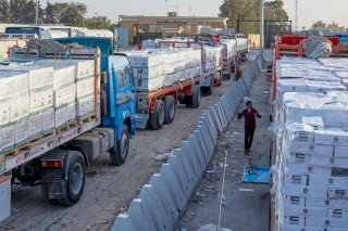 Des camions transportant de l’aide humanitaire font la queue pour entrer par la porte égyptienne du passage de Rafah, en direction d’une inspection par les autorités israéliennes avant d’entrer dans la bande de Gaza, à Rafah, en Égypte, dimanche. KEYSTONE/AP/Mohammed Arafat
