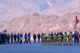 Des policiers valaisans transportent des cercueils de victimes italiennes dans un avion militaire à l'aéroport de Sion.