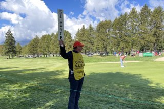 Un «marshall» demande le silence aux spectateurs présents aux abords du trou numéro 9