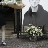 Un homme porte un bouquet de fleurs près d'un portrait de l'acteur français Gaspard Ulliel devant l'Eglise Saint Eustache à Paris jeudi peu avant son service funèbre.