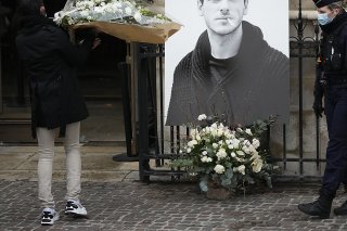 Un homme porte un bouquet de fleurs près d'un portrait de l'acteur français Gaspard Ulliel devant l'Eglise Saint Eustache à Paris jeudi peu avant son service funèbre.