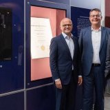 Le directeur exécutif de la Fondation Nobel, Vidar Helgesen, le recteur de l'Université de Zurich, Michael Schaepman, ainsi que le président de l'EPF Zurich, Joël Mesot, posent devant la vitrine exposant le certificat de doctorat d'Albert Einstein...