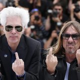Le réalisateur américain Jim Jarmusch (G) et le chanteur américain Iggy Pop (D) font un doigt d'honneur aux photographes à Cannes en 2016 quand ils présentaient "Gimme Danger", un documentaire, consacré au groupe de rock, les Stooges.