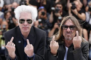 Le réalisateur américain Jim Jarmusch (G) et le chanteur américain Iggy Pop (D) font un doigt d'honneur aux photographes à Cannes en 2016 quand ils présentaient "Gimme Danger", un documentaire, consacré au groupe de rock, les Stooges.