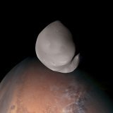 Cette image composite fournie par l'Agence spatiale des Émirats arabes unis montre la lune martienne Deimos au premier plan. C'est la première fois depuis 1977 qu'un engin spatial survole de si près ce satellite naturel rarement observé.