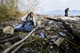 Des benevoles en action ramassent des dechets principalement du plastique et du sagex lors de l'action nettoyage de la Reserve du Fort sur les berges du Leman ce samedi 7 avril 2018 a Noville.